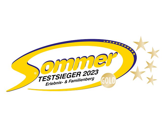 Ein gelb-blaues Logo mit der Aufschrift 'Sommer Testsieger 2023', darunter 'Erlebnis- & Familienberg'. Ein goldener Kreis mit dem Wort 'Gold' ist enthalten.