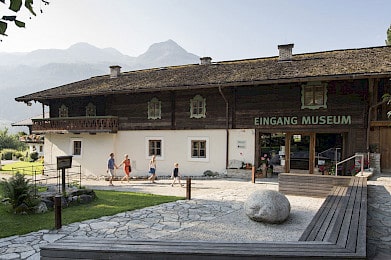 Vstup do muzea Bramberg v národním parku Vysoké Taury – tradiční selský dům s expozicemi o minerálech, smaragdech a regionální historii, oblíbený výletní cíl pro rodiny.
