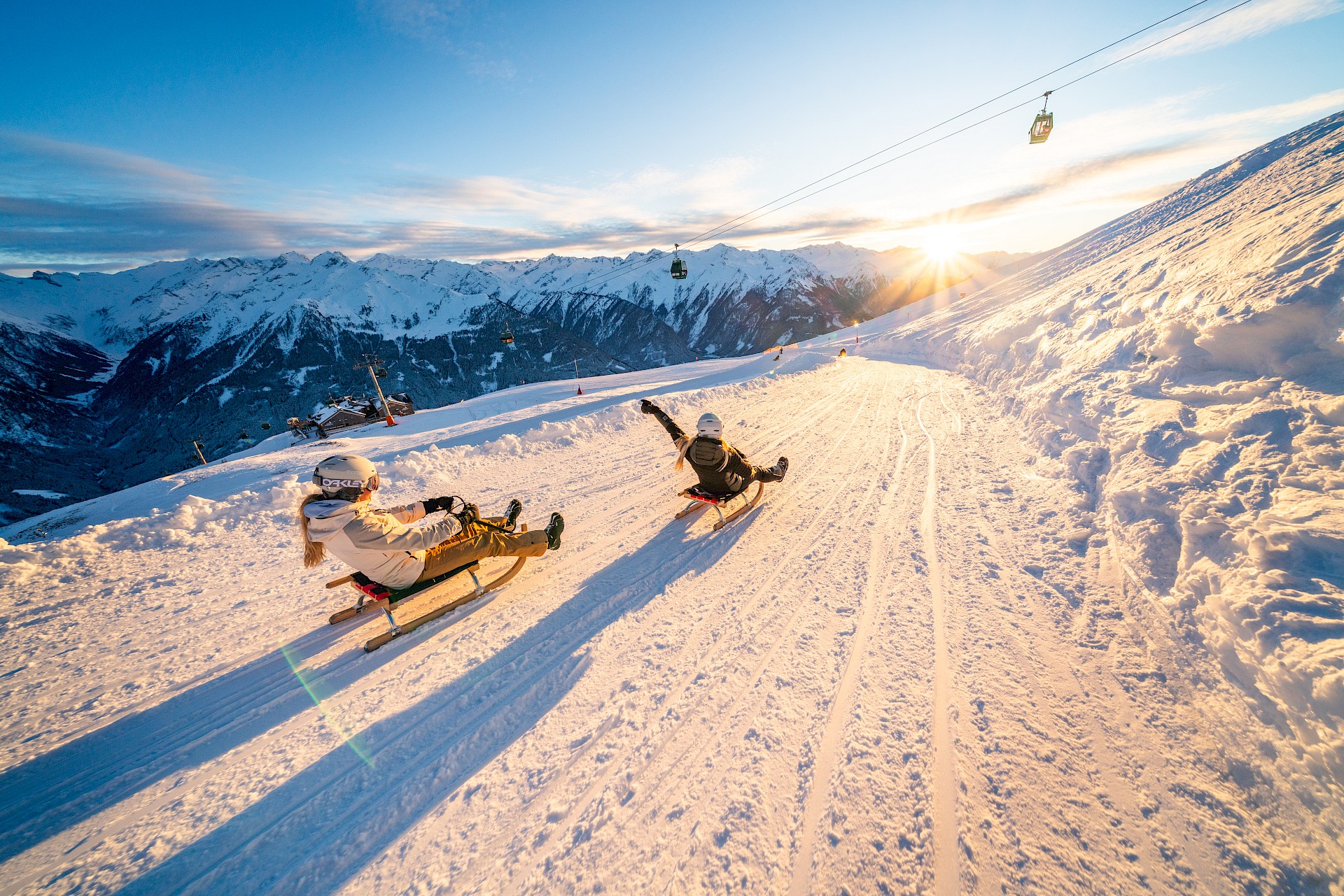 Rodelspaß auf der längsten beleuchteten Rodelbahn der Welt in der Wildkogel-Arena, 14 km Wintervergnügen mit Panoramablick auf die Hohen Tauern bei Sonnenuntergang.
