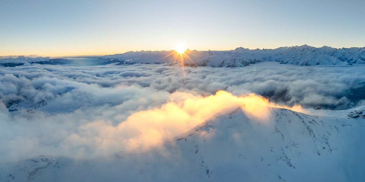 Atemberaubender Sonnenaufgang über dem Wolkenmeer in der verschneiten Wildkogel-Arena – Winterpanorama mit Alpenblick im Salzburger Land. uk-cover