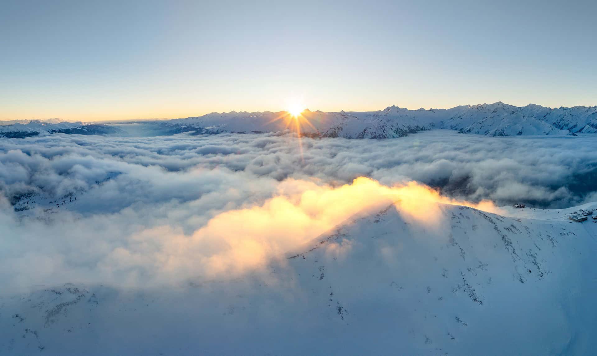 Atemberaubender Sonnenaufgang über dem Wolkenmeer in der verschneiten Wildkogel-Arena – Winterpanorama mit Alpenblick im Salzburger Land.