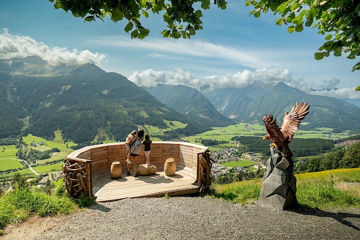 Mutter und Töchter genießen den weiten Ausblick von einer Panorama-Plattform am Erlebnisweg „Adler Toni Weg“ in der Wildkogel-Arena.