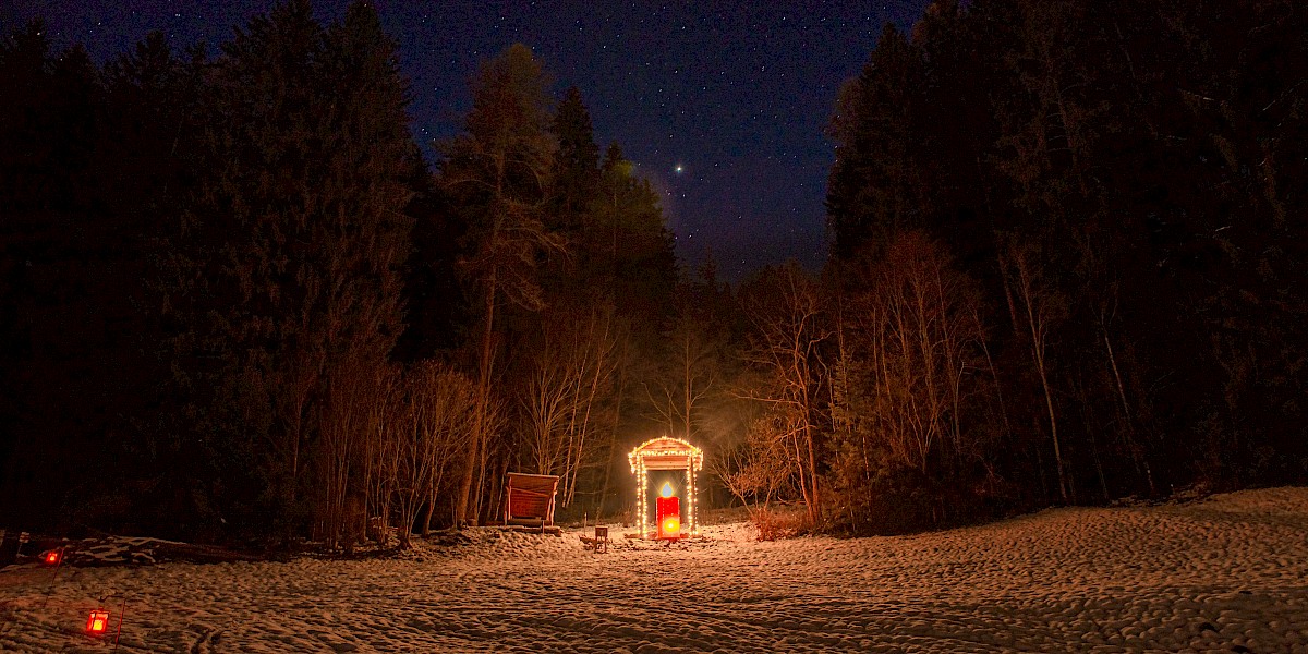 Große, warm beleuchtete Laterne am Laternenweg in Bramberg, umgeben von verschneiter Waldlichtung in der Nacht. uk-cover