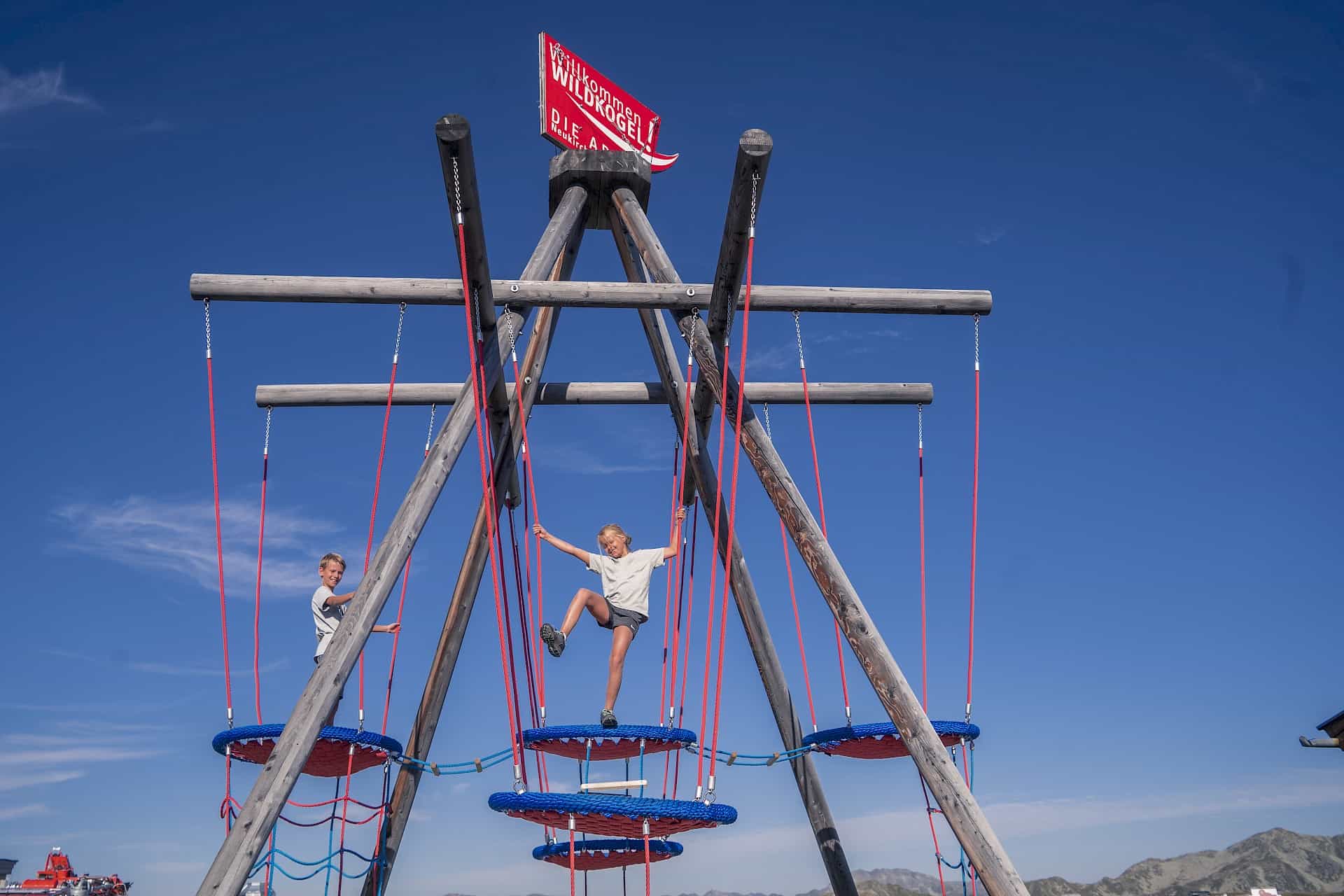 Children climbing in the high ropes area of the Kogel-Mogel Adventure Arena on the Wildkogel – playtime fun at over 2,000 metres with views of the surrounding Alps.