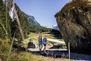 Zwei Wanderinnen im Habachtal in der Wildkogel-Arena, umgeben von Wäldern, Felsformationen und Gletscherblick – unberührte Natur im Nationalpark Hohe Tauern erleben.